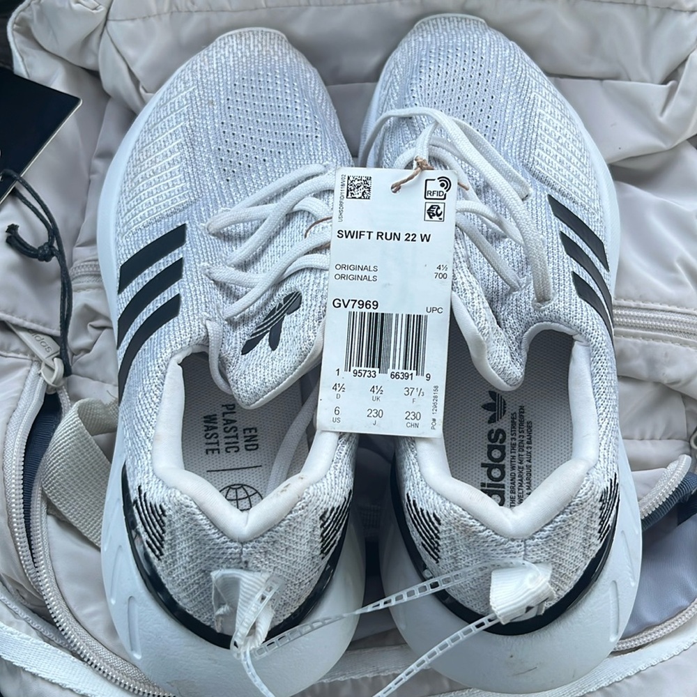 A pair of size 6 women’s adidas swift run 22 with a Essentials 2 backpack